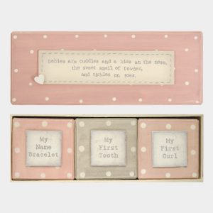 3 Set baby memory boxes in presentation box. Words on presentation box read Babies are cuddles and a kiss on the nose, the sweet smell of powder, and tickles on toes. Words on 1st box read My first tooth, 2nd box read My first curl, 3rd box read My name bracelet